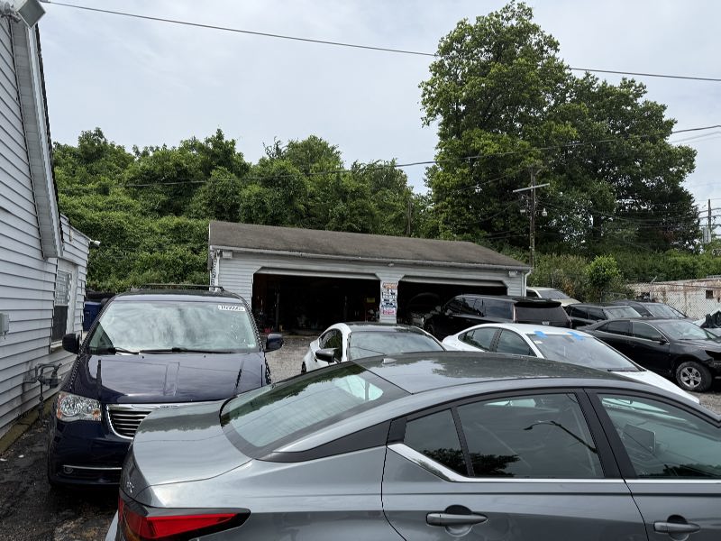 IMG_7800 Small auto repair shop with a two-bay garage and several parked cars in front.